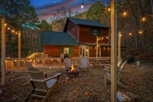 eine Gruppe von Stühlen um eine Feuerstelle vor einem Blockhaus in der Unterkunft Secluded~ 3 Kings~ Games~ Hot Tub + Fire Pit~ Pets in Cove Creek Cascades