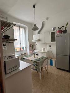 uma cozinha com uma mesa e uma geladeira branca em Appartamento confortevole em Génova