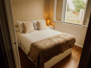 a bedroom with a large bed with a window at Casa El Refugio in Monforte de Lemos