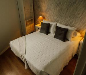 a bedroom with a large white bed with four pillows at Casa El Refugio in Monforte de Lemos