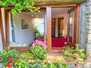 Una habitación con una ventana con un sofá rojo y flores. en Casa delle Chicche - Imperia, en Imperia