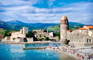 un gruppo di persone su una spiaggia vicino a un castello di Maison avec piscine VIVES 8 couchages 4 chambres a Vivès