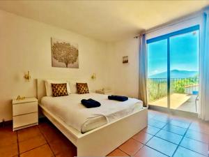 una camera da letto con un letto grande e una grande finestra di Maison avec piscine VIVES 8 couchages 4 chambres a Vivès