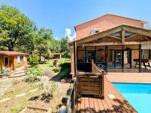a house with a wooden deck and a swimming pool at L'Adret du Ventoux in Flassan