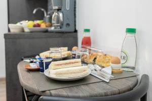 a table with sandwiches and eggs and food on it at Olimpico Luxury Rooms in Rome