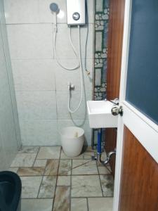 a bathroom with a shower and a toilet and a sink at Mountain cove villa in Pagudpud