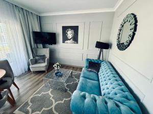 salon z niebieską kanapą i stołem w obiekcie Apartament Glamour - 5 Mórz - Basen - SPA - Sauna w Sianożętach