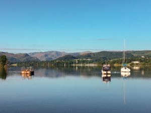 zwei Boote sind auf einem großen Wasserkörper angedockt in der Unterkunft Smithy Cottage in Keldhead + 1 Foto