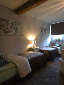 a hotel room with two beds and a couch at Boerderijwoning in Maastricht