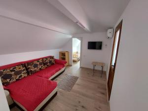 a living room with a red couch and a table at Casa Anne in Mangalia