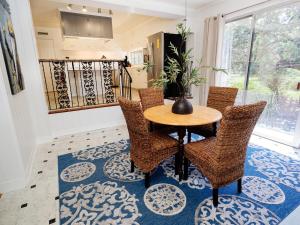 a dining room with a table and chairs on a blue rug at The Nest in Mobile