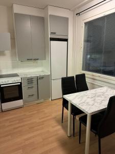a kitchen with a table and chairs and a counter top at Lägenhet Kaskö in Kaskö +4 photos