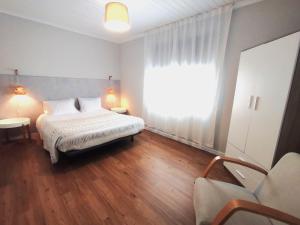 ein Schlafzimmer mit einem Bett und einem großen Fenster in der Unterkunft Casa de São Roque Açores in Ponta Delgada