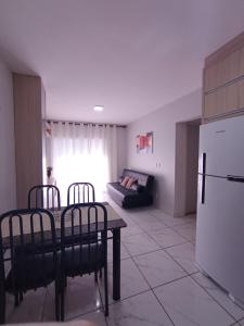 a kitchen with a table and chairs and a refrigerator at Confortável Apto de 2 Quartos - Lagoa Quente in Caldas Novas