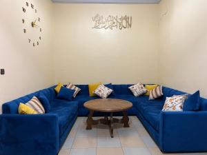 een woonkamer met een blauwe bank en een tafel bij Al houceima in Al Hoceïma +1 foto