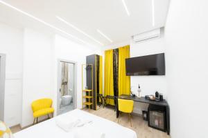 a hotel room with a desk and yellow chairs at Olimpico Luxury Rooms in Rome