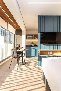 a room with a bed and a table and a kitchen at Pivô Pamplona by Viva - Apartamentos novos e espaçosos ao lado da Av Paulista in Sao Paulo