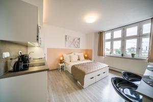 a bedroom with a bed and a large window at APARTIA Skořepka 15, Brno-center in Brno