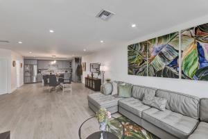 ein Wohnzimmer mit einer Couch und einem Gemälde an der Wand in der Unterkunft Beachside Villa in Fort Lauderdale