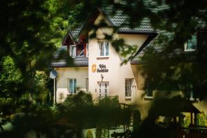 duży biały budynek z czarnym dachem w obiekcie Róża Sudetów w mieście Duszniki Zdrój