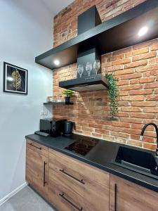 a kitchen with a brick wall and a stove at Sky Mirror jacuzzi in Krakow +9 photos