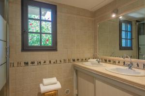 une salle de bain avec deux lavabos et une fenêtre dans l'établissement Villa Vallée Longa - Tarra Zuria, à Bonifacio