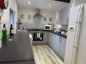 a kitchen with white appliances and a black counter top at Room 2 Shared House in L6 in Liverpool
