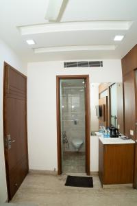 a bathroom with a sink and a toilet in a room at Grand Hridey 1 minute from Railway Station in Amritsar