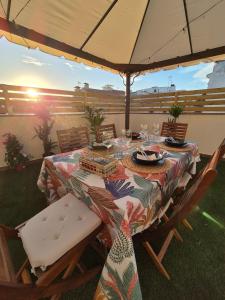 a table with chairs and an umbrella on a patio at Gran terrassa al cantó del mar in Canet de Mar