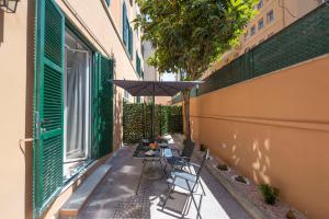 a patio with a table and an umbrella at Olimpico Luxury Rooms in Rome