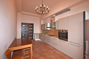 a kitchen with a wooden table and a chandelier at Teryan street, 4 bedrooms Luxury and Grande apartment with Spacious balcony TT606 in Yerevan