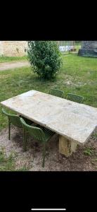 un grande tavolo di pietra con due sedie attorno di La petite Chapelle a LʼIsle-sur-Serein