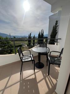 a patio with three chairs and a table on a balcony at Amare Apartaments in Orikum +55 photos