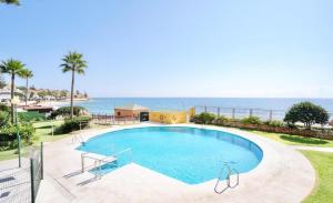 a swimming pool with the ocean in the background at Beachfront studio in Sitio de Calahonda