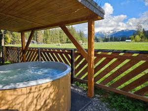 a hot tub sitting under a wooden gazebo at Domek drewniany Szafran in Witów