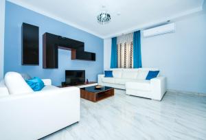 a living room with white furniture and blue walls at The Waves holiday apartment in Marsaxlokk