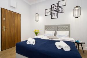 a bedroom with a blue bed with towels on it at Old Town Residence at Topolowa in Krakow