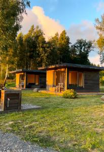a cabin in the woods with a yard at Tūjas dīķi in Tūja