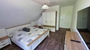 a bedroom with a bed and a wooden floor at Gästehaus Hoofdmann Ferienwohnungen in Upgant-Schott +41 photos