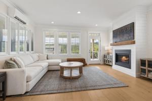 Una sala de estar con un sofá blanco y una chimenea. en Tori Pines by Seabrook Hospitality, en Pacific Beach