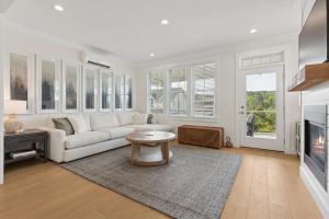 Una sala de estar con un sofá blanco y una mesa. en Tori Pines by Seabrook Hospitality, en Pacific Beach