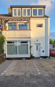 a house with a parking lot in front of it at Welkom op Texel privé studio in De Koog