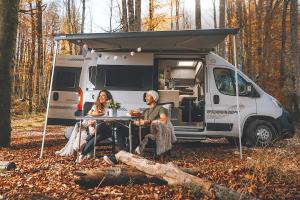 森克Robeta Ares的两个人坐在房车前的桌子旁