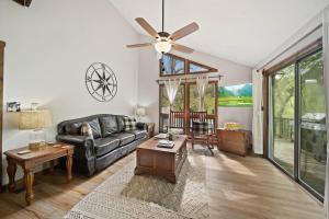 a living room with a couch and a ceiling fan at Riverside Mountain Retreat in Boone