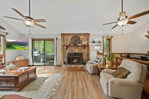 a living room with a fireplace and two fans at Riverside Mountain Retreat in Boone