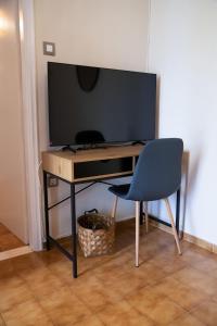 a desk with a blue chair and a television at Villa Marina in Posidhonía
