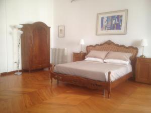 Schlafzimmer mit einem Bett mit einem Kopfteil aus Holz in der Unterkunft Lo Studio di Joyce in Triest