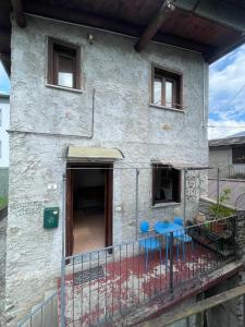 une maison avec 2 chaises bleues sur un balcon dans l'établissement Casa Carolina, à Montagna in Valtellina