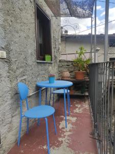 une table bleue et deux chaises sur un balcon dans l'établissement Casa Carolina, à Montagna in Valtellina