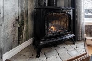 a fireplace in a room with a brick floor at Blanche du Cap A stone's throw from Le Massif in Charlevoix in Petite-Rivière-Saint-François